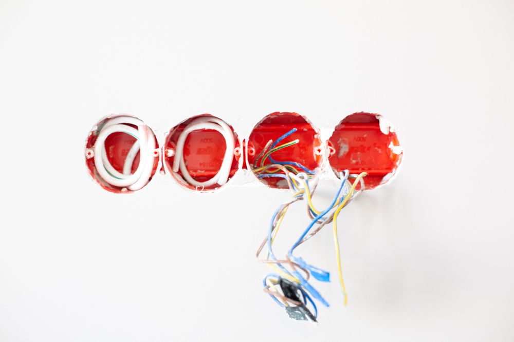 Bekötésre előkészített szerelvénydobozok és vezetékek a falban villanyszerelés közben